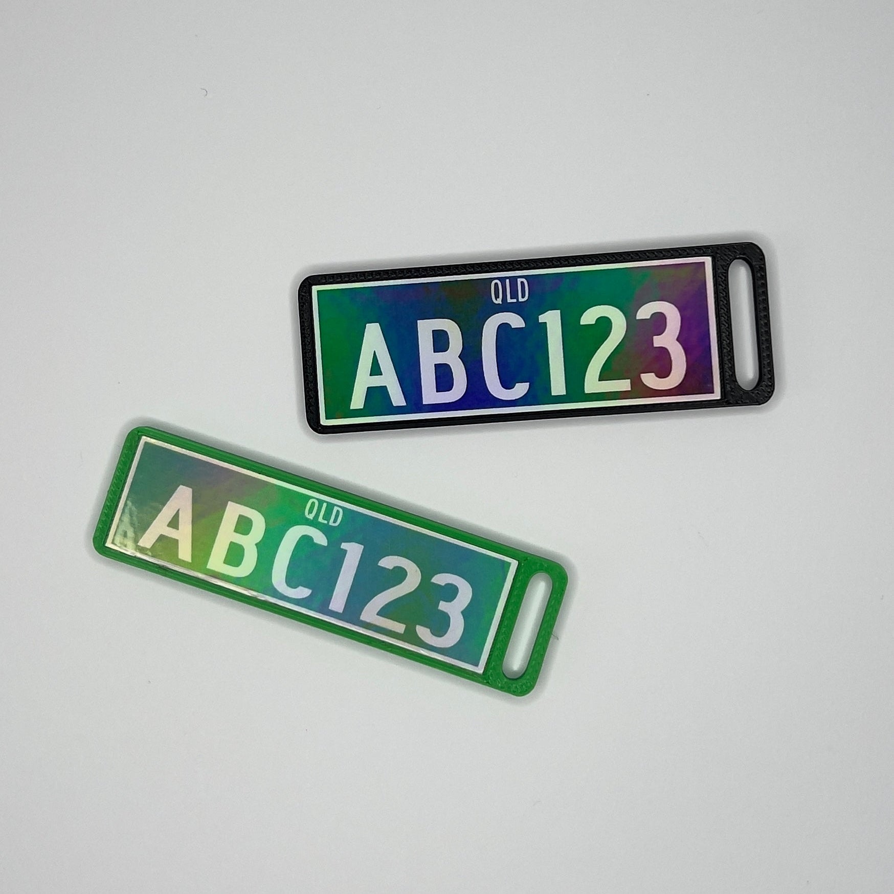 Two license plate-shaped keychains with 'ABC123' text on a light gray background